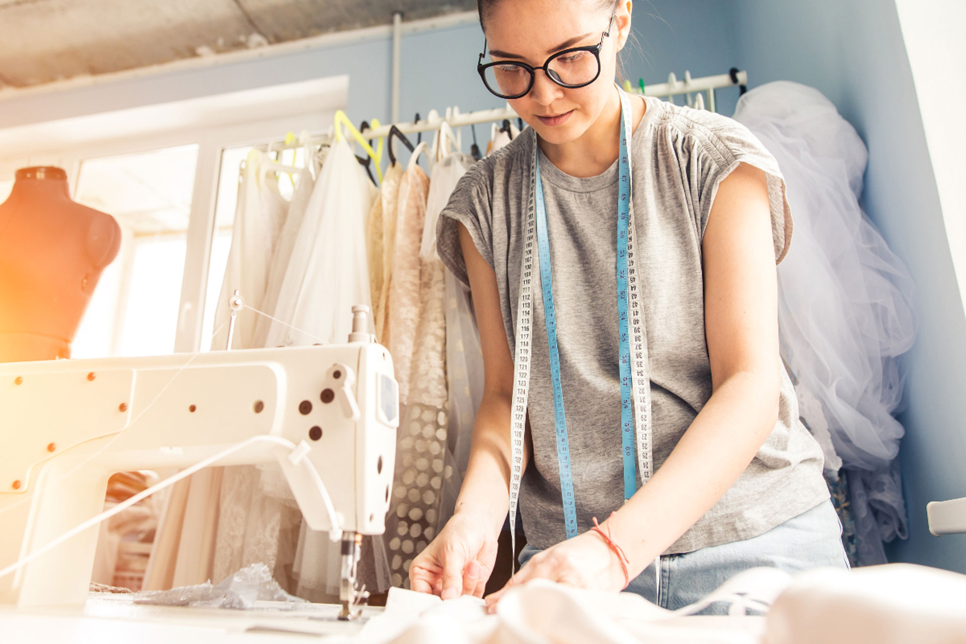 Woman At Sewing Machine With Measuring Tape 1200X800